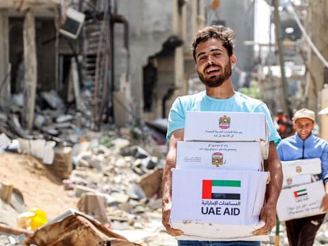 Men walk through rubble past damaged buildings with humanitarian aid packages collected from a drop over the northern Gaza Strip on April 23, 2024 amid the ongoing conflict in the Palestinian territory between Israel and the militant group Hamas.