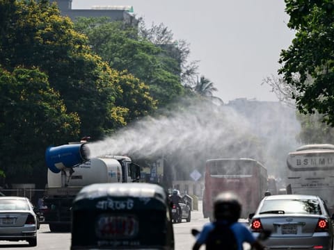 A vehicle of the Dhaka North City Corporation (DNCC) sprays water along a busy road to lower the temperature amidst a heatwave in Dhaka on April 27, 2024.