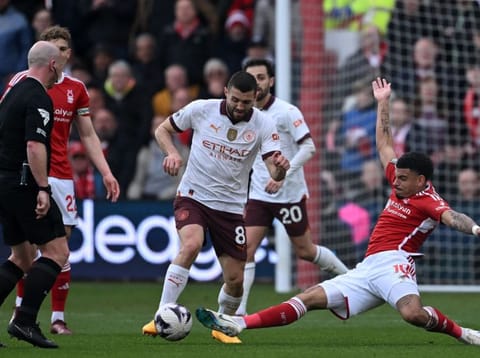 Manchester City's Croatian midfielder Mateo Kovacic (centre) is tackled by Nottingham Forest's English midfielder Morgan Gibbs-White during the English Premier League football match at The City Ground in Nottingham, central England, on Sunday.