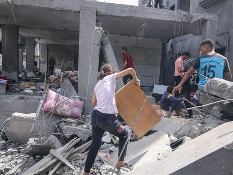 Palestinians sort through the rubble of destroyed buildings following an Israeli airstrike in a residential neighborhood at the Nuseirat refugee camp, central Gaza.