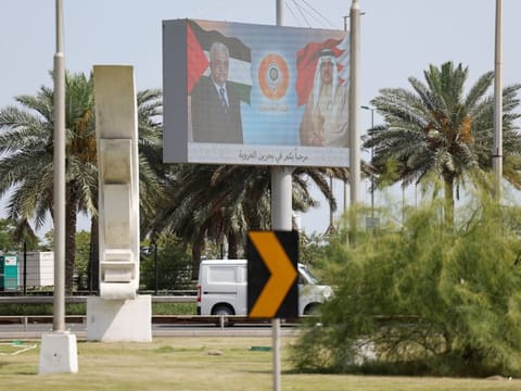 A billboard displays photos of Bahrain's King Hamad bin Eisa Al Khalifa and Palestinian President Mahmoud Abbas with logo of the 33rd Arab Summit that will take place in Manama on May 16, 2024.