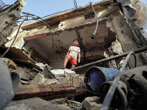 A Palestinian boy stands on the rubble of a destroyed house in Nuseirat following Israeli bombardment overnight on May 23, 2024, amid continuing battles between Israel and Hamas in the Gaza Strip.