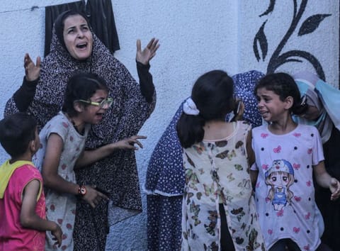 Palestinians react after an Israeli strike on a building in Nuseirat on May 25, 2024.