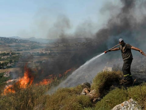 A Lebanese firefighter douses a blaze that swept over fields hit by Israeli shelling in southern Lebanon near the border with Israel, on June 3, 2024, amid ongoing cross-border clashes between Israeli troops and Hezbollah fighters.