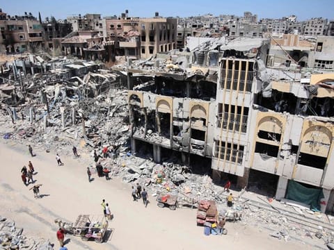 Palestinians carry some salvaged belongings as they leave the Jabalia refugee camp in the northern Gaza Strip after they returned briefly to check on their homes on May 31, 2024.