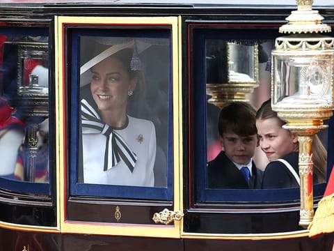 Britain's Catherine, Princess of Wales, smiles next to Britain's Princess Charlotte of Wales (R) and Britain's Prince Louis of Wales (C) inside the Glass State Coach on their way to Horse Guards Parade for the King's Birthday Parade "Trooping the Colour" in London on June 15, 2024.