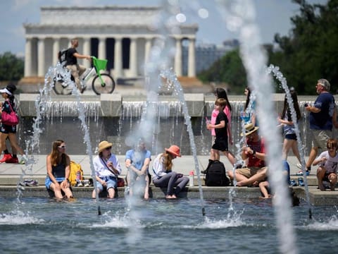 Americans cool off at the US World War II Memorial in Washington, DC, on June 19, 2024. Extreme heat and high humidity smothered the central and northeastern United States, with temperature records expected to melt away in the coming days, authorities warned, as wildfires sizzled in the west.