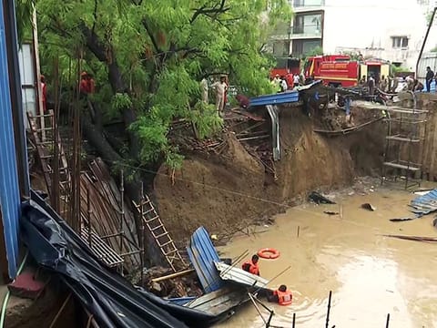 A rescue operation underway by NDRF, fire brigade and police officials after three labourers fell into a pit of an under-construction building in Delhi's Vasant Vihar area on Friday. The labourers were living in temporary huts near the site and the huts collapsed into the pit due to heavy rainfall.