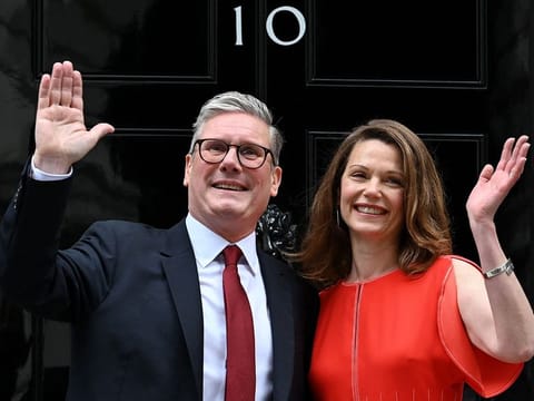 Britain's incoming Prime Minister Keir Starmer and leader of the Labour Party, and his wife Victoria wave as they pose on the steps of 10 Downing Street in London on July 5, 2024, a day after Britain held a general election.