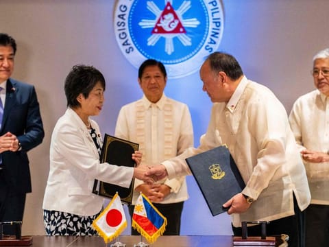 Japan's Foreign Minister Yoko Kamikawa and Philippine Defence Minister Gilberto Teodoro shake hands after signing the Reciprocal Access Agreement at the Malacanang Palace in Manila on July 8, 2024.