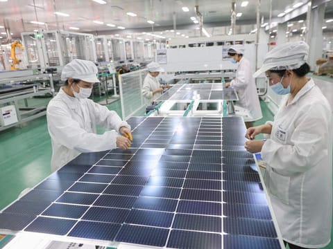 Employees working on solar photovoltaic modules that will be exported at a factory in Lianyungang, in China's eastern Jiangsu province.