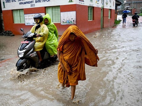 People wade through flood after Hanumante river overflowed following heavy rain in Bhaktapur on the outskirts of Kathmandu.