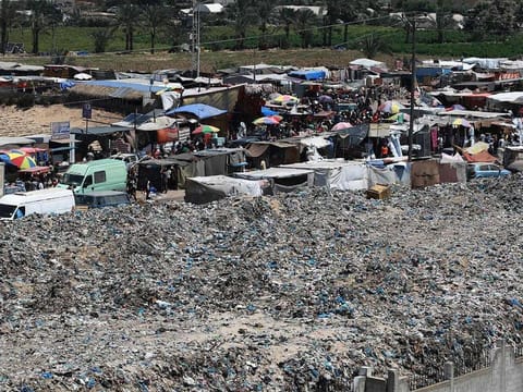 A pile of garbage surrounds a camp for displaced people in Khan Yunis in the southern Gaza Strip on July 18, 2024.
