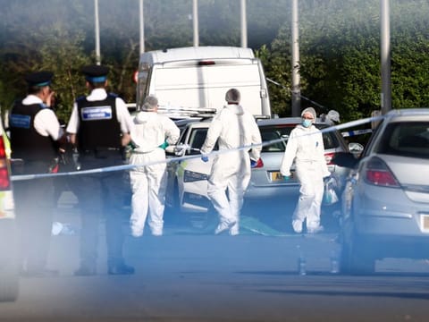 Police officers and forensic personnel stand behind a cordon on Hart Street in Southport, northwest England, on July 29, 2024, following a knife attack.