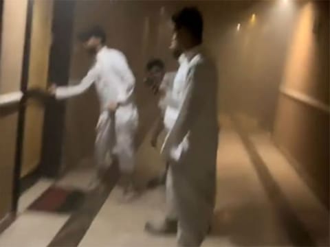 The quick-thinking group forced open the door, rescuing the woman just before firefighters arrived.