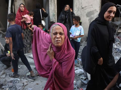 A woman reacts as people inspect the damage following Israeli bombardment in Gaza City's Sheikh Radwan neighbourhood on August 11, 2024.