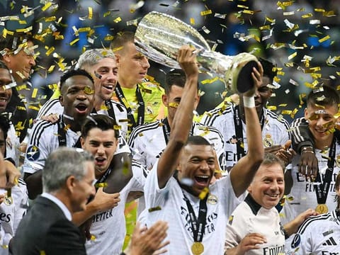 Real Madrid's French forward Kylian Mbappe celebrates with the trophy after the UEFA Super Cup football match between Real Madrid and Atalanta BC in Warsaw, on August 14, 2024.