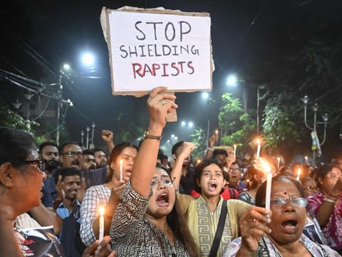 Medical professionals and activists hold posters and candles as they take part in a midnight protest to condemn the rape and murder of a young medic, in Kolkata on August 14, 2024, on the eve of Indias 78th Independence Day celebrations.