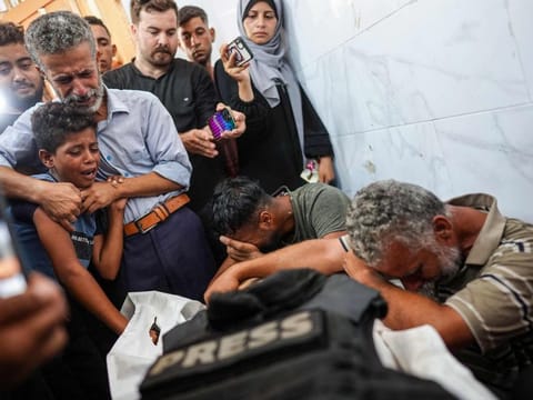 Relatives mourn over the body of photojournalist Ibrahim Muhareb, who was killed as he was covering the advance of Israeli forces north of Khan Yunis, Gaza