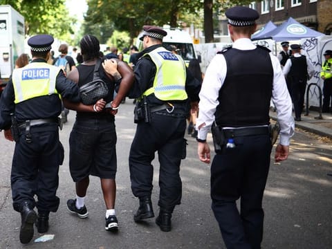 Police officers make an arrest at the Notting Hill Carnival in west London on August 26, 2024. (Photo by HENRY NICHOLLS / AFP)