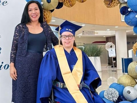 Year 13 student with cerebral palsy Erika Gladikkh with her shadow teacher Joan Laza Carreon at her graduation.
