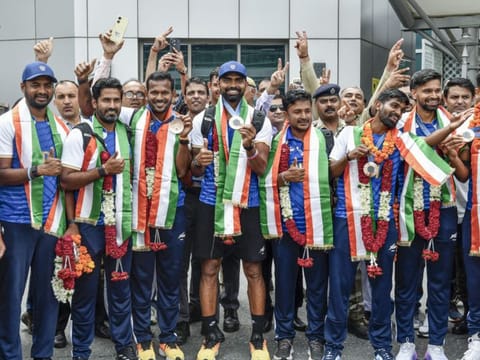 India's bronze medal-winning men's hockey team pose for a picture on their arrival at IGI airport, in New Delhi.
