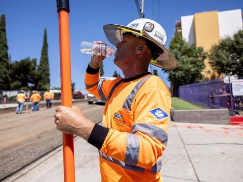 A road worker drinks water on a construction site as southern California is facing a heatwave, in Los Angeles.