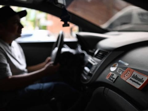 A sticker with the phrase "Bitcoin accepted here" is seen inside the vehicle of taxi driver Napoleon Osorio in San Salvador on September 4, 2024.