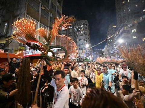 Members of the fire dragon dance team spin balls of joss sticks during the Tai Hang Fire Dragon Dance, in Hong Kong.