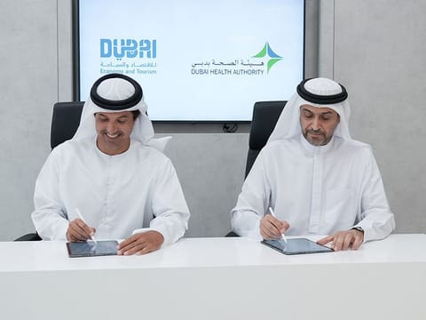 Helal Saeed Almarri (L), Director-General of Dubai Department of Economy and Tourism, and Awadh Seghayer Al Ketbi, Director-General of Dubai Health Authority, signing the MoU