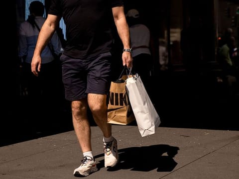 A shopper carries a Nike bag in New York, US, on Friday, Sept. 13, 2024.