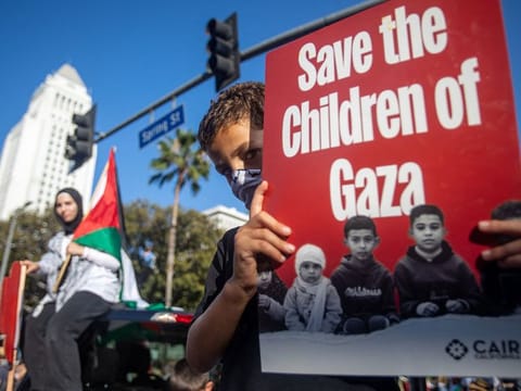 A young protestor holds a sign reading "Save the Children of Gaza" as people demonstrate to mark one year of the war between Hamas and Israel in Los Angeles, on October 5, 2024.