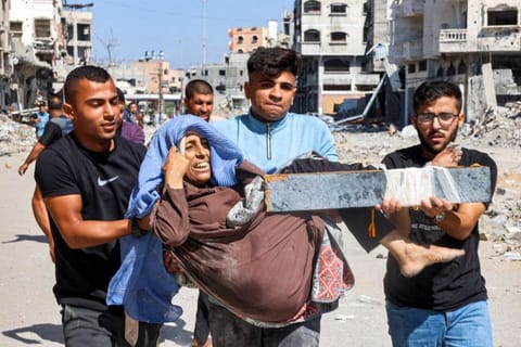 Men carry injured woman to be evacuated in the Jabalia camp for Palestinian refugees in the northern Gaza Strip on October 9, 2024 amid the ongoing war in the Palestinian territory between Israel and Hamas.