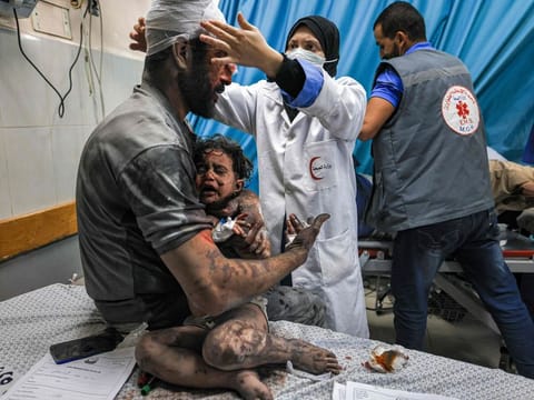 A man holds a child, survivors of Israeli bombardment, as they are treated at a trauma ward at Nasser hospital in Khan Yunis in the southern Gaza Strip on October 24, 2023.