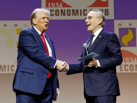 Former US President and Republican presidential candidate Donald Trump (L) greets US Ambassador to the United Arab Emirates and the President of Walbridge John Rakolta Jr., during an address to the Detroit Economic Club held at the Motor City Casino in Detroit, Michigan on October 10, 2024.