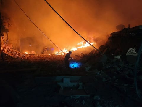 A rescuer searches for survivors at the site of an Israeli airstrike that targeted the southern Lebanese city of Nabatiyeh. Israel's intense bombardment campaign has killed more than 1,260 people in Lebanon.