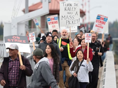 File photo: People carry sings as they march towards Boeing Field following a strike rally for the International Association of Machinists and Aerospace Workers (IAM) at the Seattle Union Hall in Seattle, Washington, on October 15, 2024.