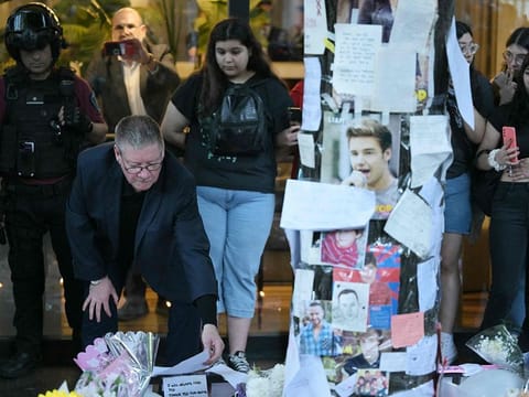 Geoff Payne (L), the father of One Direction pop singer Liam Payne, looks at a note placed where fans paid tribute to his late son outside the CasaSur Hotel in Buenos Aires on October 18, 2024.