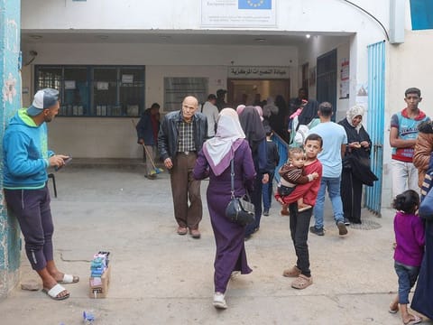 Palestinians walk into a healthcare clinic at the UNRWA (United Nations Relief and Works Agency) centre at the Nuseirat refugee camp in the central Gaza Strip on October 29, 2024.