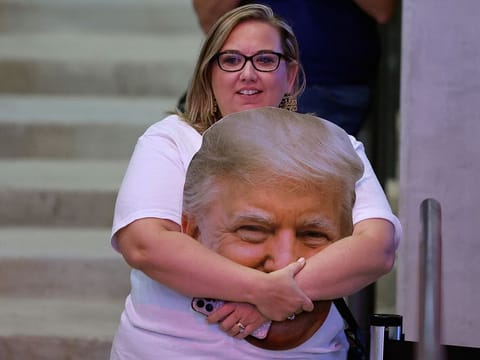 A supporter holds a cutout photograph of Republican presidential nominee, former President Donald Trump during a campaign rally at the Atrium Health Amphitheater on November 03, 2024 in Macon, Georgia.