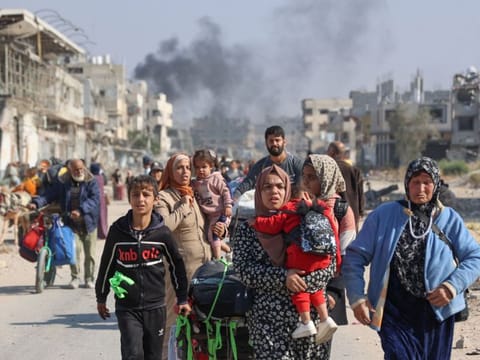 Palestinians displaced from shelters in Beit Hanoun cross the main Salaheddine road into Jabalia in the northern Gaza Strip following Israeli army evacuation orders on November 12, 2024.