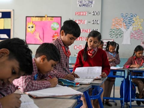 Children attend a class at a school in New Delhi on December 3, 2024. Parents and children rejoiced on December 3 as schools reopened for physical classes in New Delhi despite "very unhealthy" pollution levels persisting in the Indian capital.
