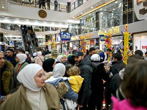 People shop at a shopping mall in the town of Al Dana, near Sarmada, in the northern Syrian province of Idlib on December 13, 2024. The crowd wanders in awe through the aisles saturated with lights, dazzled by the abundance of goods displayed before them in the heart of the former rebel stronghold.