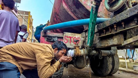 A man drinks water from a tanker amid a contaminated water crisis at Bhagirathpura, in Indore, Saturday, Jan. 3, 2026 