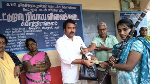An official handing over a Pongal kit to a PDS beneficiary at a ration shop in Tirukazhukundram in Chengalpattu 