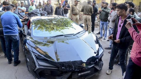 People gather around a luxury car which collided with a rickshaw, injuring three people, in Kanpur on Sunday (February 8, 2026).