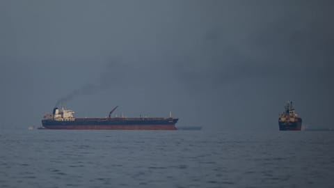 Oil tankers and cargo ships line up in the Strait of Hormuz as seen from Khor Fakkan, United Arab Emirates.