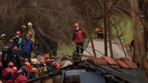 Rescue teams and firefighters search the site where two residential buildings collapsed in Istanbul