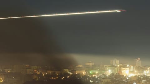  A Middle East Airlines plane flies as smoke rises from Israeli airstrikes in Beirut, Lebanon, in March 2026