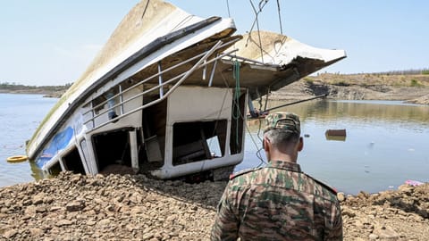 A security official present at the site as the NDRF and other rescue personnel conduct an operation to recover the cruise boat, carrying 29 passengers and two crew members, that overturned in Bargi Dam due to a sudden storm, in Jabalpur district, Madhya Pradesh, Friday, May 1, 2026. The death toll rose to nine and 28 others were rescued after the incident.